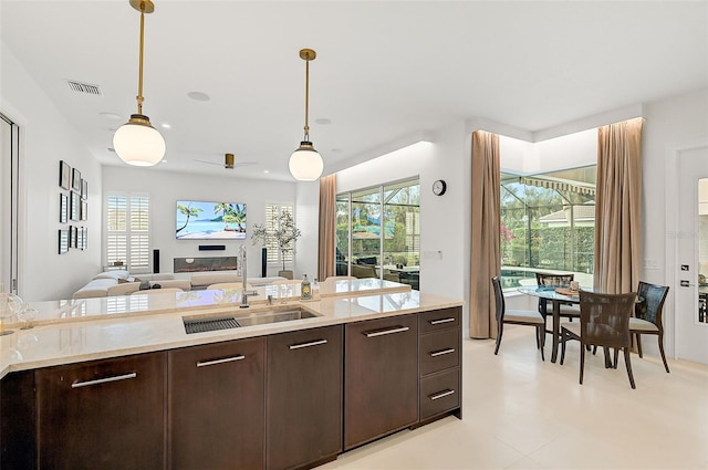 2112 Calusa Lakes Blvd, Nokomis, FL 34275 - kitchen with dark brown cabinetry, light countertops, and hanging light fixtures