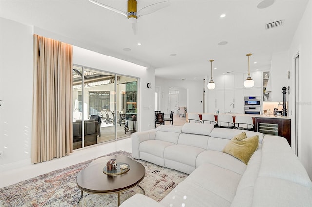 living room featuring ceiling fan and sink