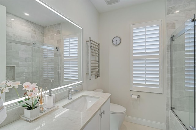 bathroom featuring vanity, a healthy amount of sunlight, toilet, and radiator heating unit