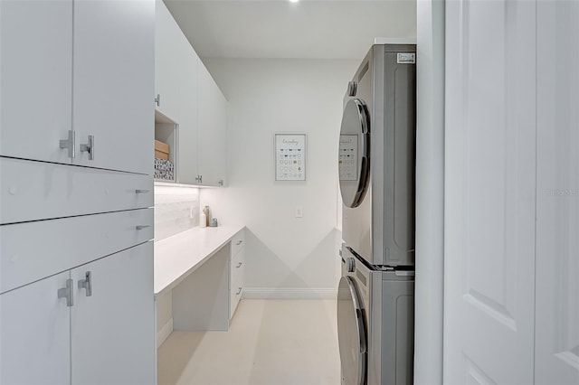 laundry area with cabinets and stacked washer and dryer