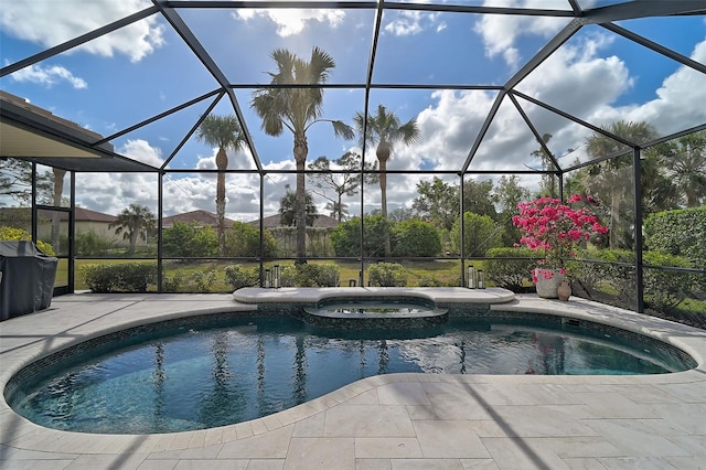 view of pool featuring glass enclosure, an in ground hot tub, and a patio area