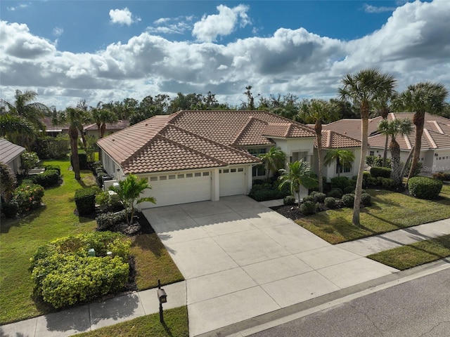 2112 Calusa Lakes Blvd, Nokomis, FL 34275 - mediterranean / spanish-style house with an attached garage, a tiled roof, a front yard, concrete driveway, and stucco siding