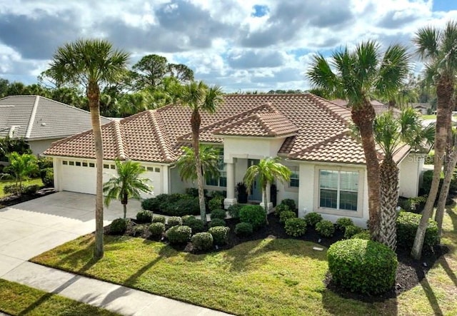 mediterranean / spanish-style home featuring a tile roof, a front yard, concrete driveway, stucco siding, and an attached garage