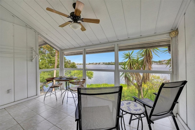 sunroom with a healthy amount of sunlight, a water view, and lofted ceiling