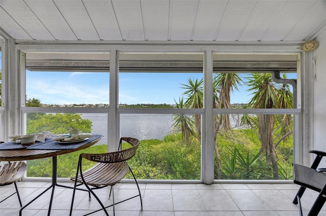 sunroom featuring a water view