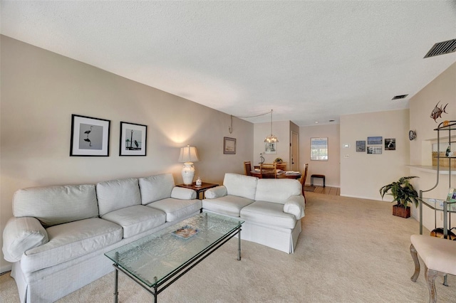 carpeted living room featuring a textured ceiling and an inviting chandelier