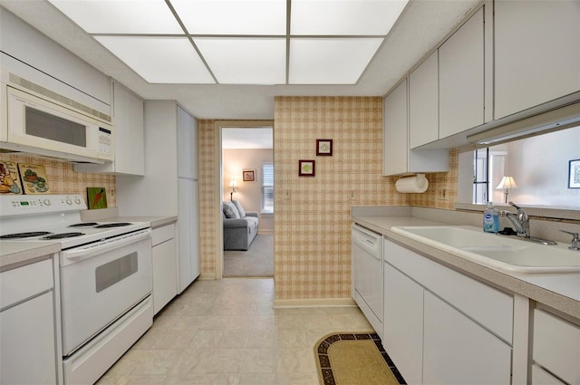 kitchen featuring white cabinets, white appliances, and sink