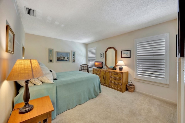 bedroom featuring a textured ceiling and light colored carpet