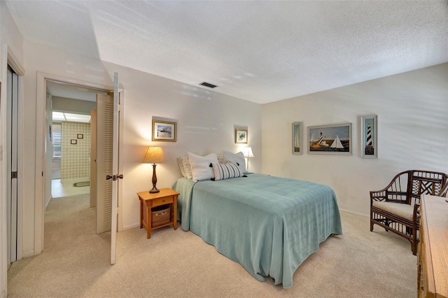 bedroom featuring light carpet and a textured ceiling