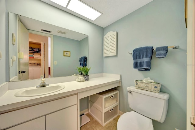 bathroom with tile patterned flooring, vanity, and toilet