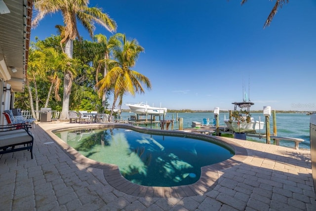 view of swimming pool featuring a patio area, a dock, and a water view