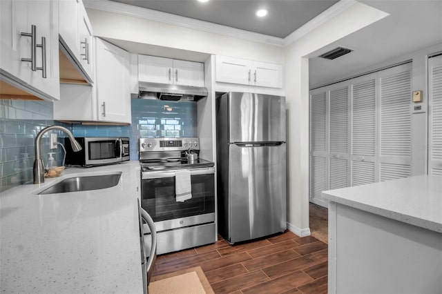 kitchen with decorative backsplash, light stone counters, stainless steel appliances, sink, and white cabinets