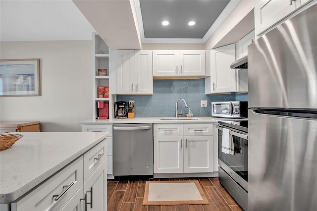 kitchen with white cabinets, stainless steel appliances, tasteful backsplash, and sink