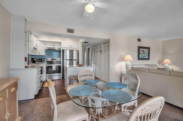 dining room with dark hardwood / wood-style floors, ceiling fan, and sink