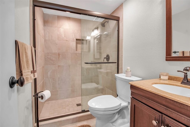 bathroom featuring vanity, toilet, and a shower with shower door