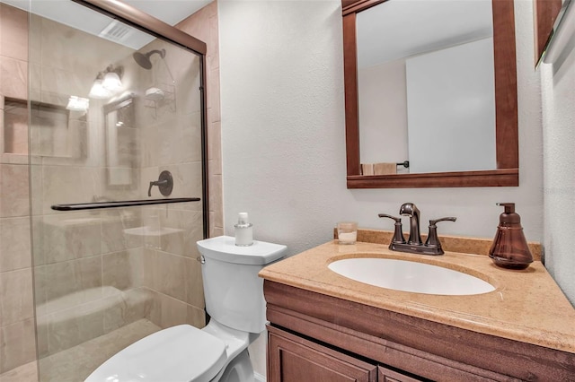 bathroom featuring vanity, an enclosed shower, and toilet