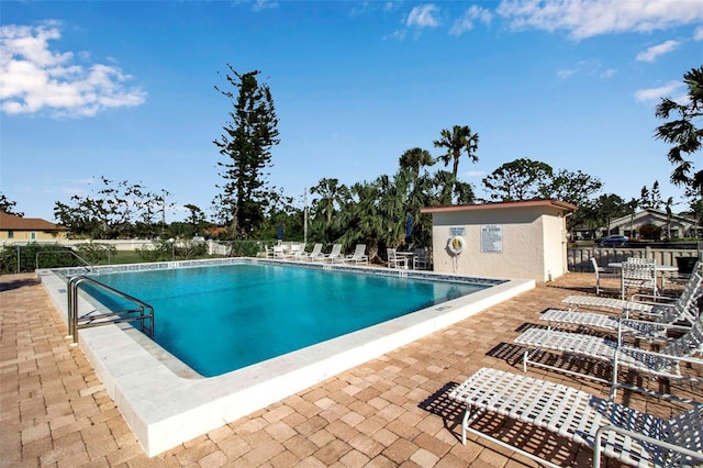 view of pool with a patio and an outdoor structure