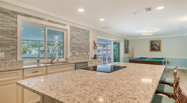 kitchen featuring sink, light stone counters, stainless steel dishwasher, a breakfast bar, and pool table