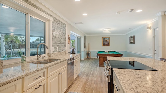 kitchen with light stone counters, stainless steel dishwasher, sink, billiards, and range