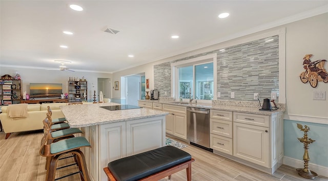 kitchen featuring a center island, stainless steel dishwasher, ceiling fan, ornamental molding, and light stone counters