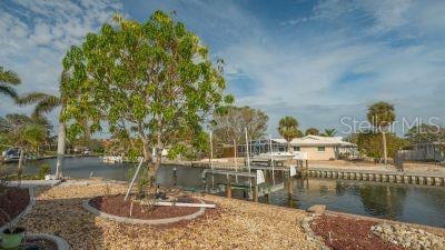 view of yard with a water view and a boat dock