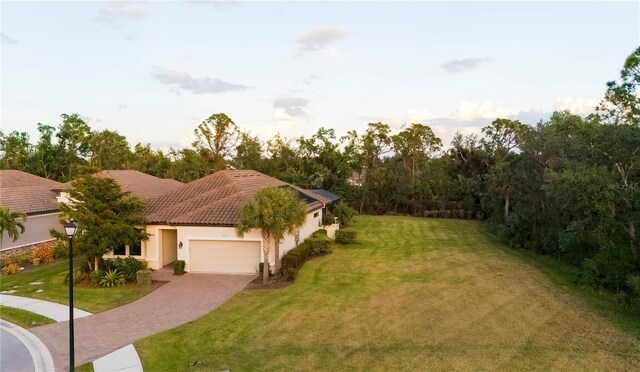 mediterranean / spanish house with a garage and a front lawn