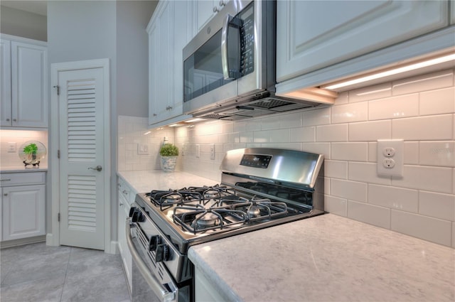 kitchen with white cabinets, backsplash, and appliances with stainless steel finishes