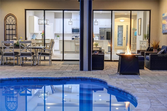 view of swimming pool featuring a fire pit and a patio