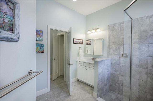 bathroom featuring tile patterned flooring, vanity, and a tile shower