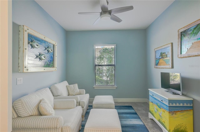 sitting room featuring ceiling fan and dark carpet