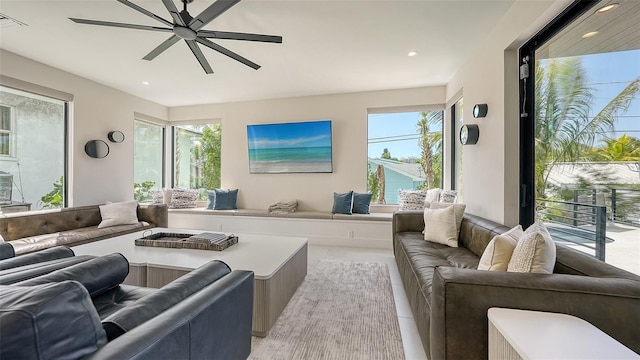 living room featuring ceiling fan, light tile patterned flooring, and a wealth of natural light