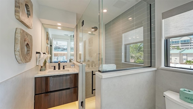 bathroom featuring vanity, toilet, and an enclosed shower