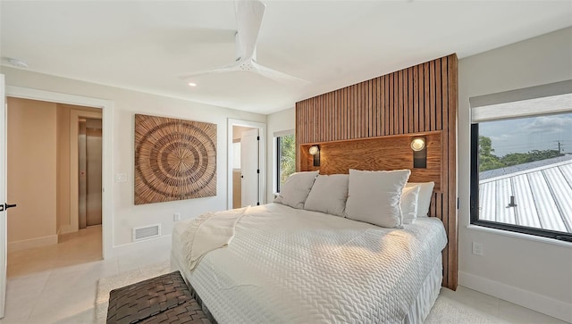 tiled bedroom featuring ceiling fan and multiple windows