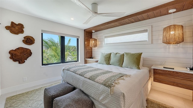 bedroom with tile patterned floors, ceiling fan, and wooden walls