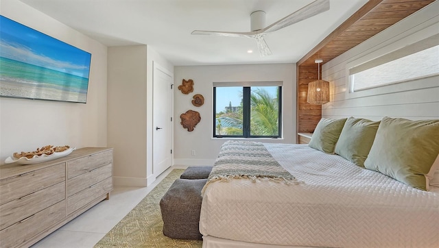 carpeted bedroom featuring ceiling fan and wooden walls