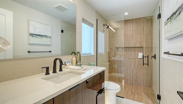 bathroom with walk in shower, decorative backsplash, vanity, and toilet