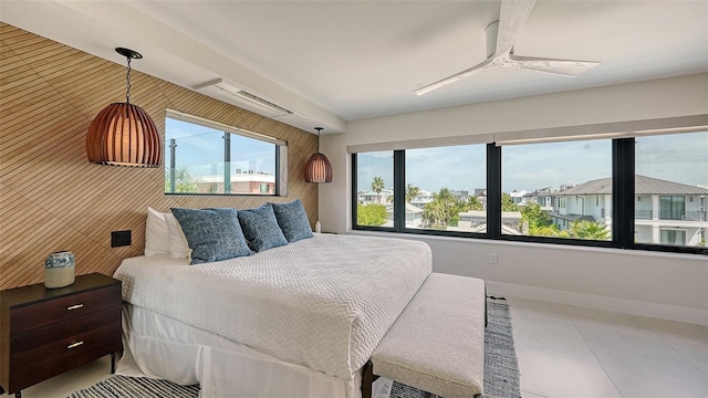 tiled bedroom with ceiling fan and a wall mounted air conditioner