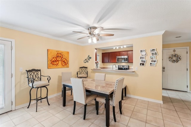 tiled dining area featuring ceiling fan and ornamental molding