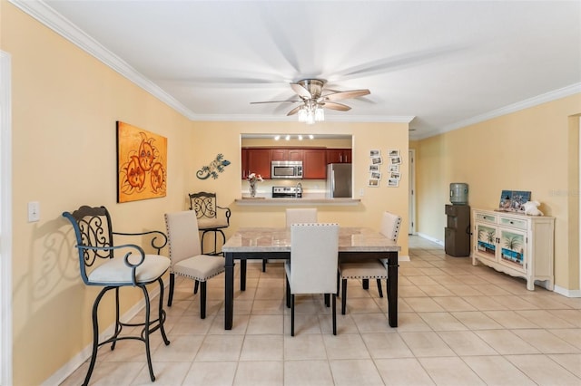 dining area with ceiling fan, ornamental molding, and light tile patterned floors