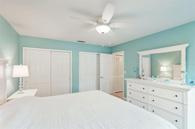 bedroom with ceiling fan and two closets