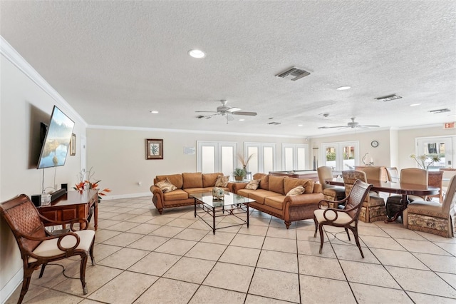 tiled living room featuring ceiling fan, ornamental molding, a textured ceiling, and french doors