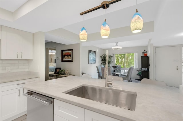 kitchen with decorative backsplash, light stone counters, dishwasher, white cabinetry, and hanging light fixtures