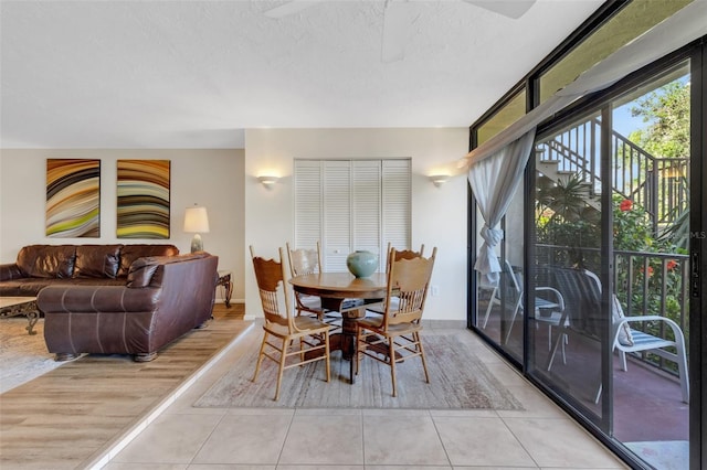 tiled dining space featuring ceiling fan and a textured ceiling