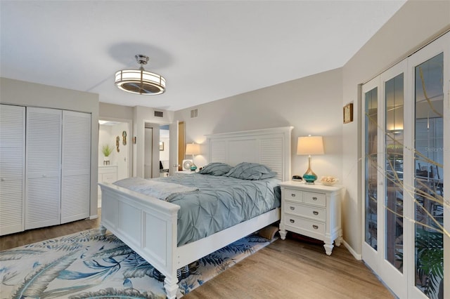 bedroom with a closet, french doors, ensuite bathroom, and wood-type flooring