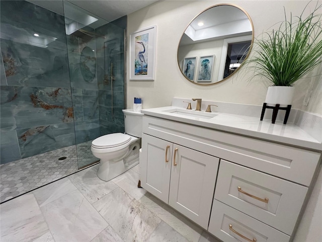 bathroom with a tile shower, vanity, and toilet