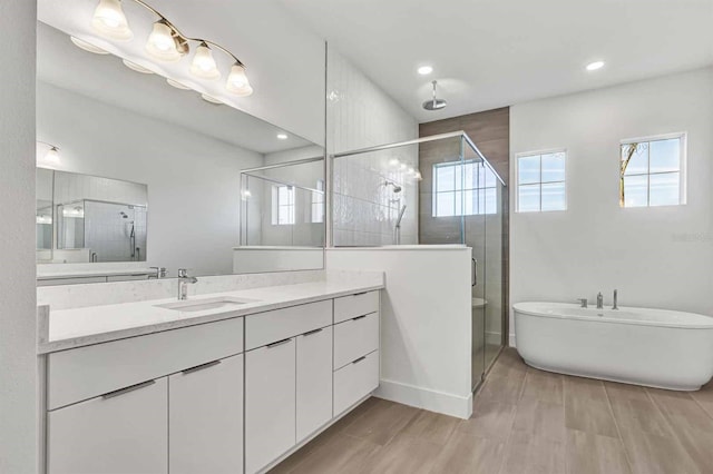 8007 Nevis Run, Bradenton, FL 34202 - full bath featuring a stall shower, vanity, recessed lighting, a freestanding bath, and wood finished floors