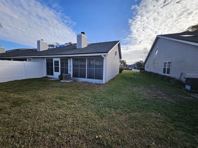 back of house featuring a yard and central AC