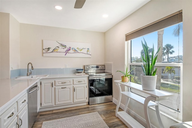 kitchen with white cabinets, stainless steel appliances, dark wood-type flooring, and sink