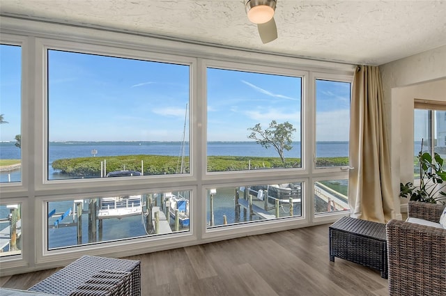 sunroom with a water view and ceiling fan