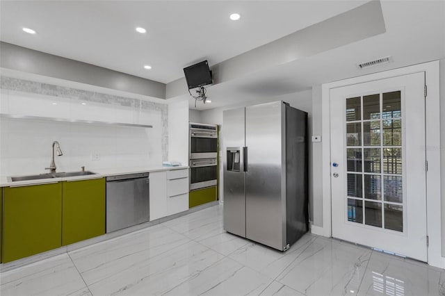 kitchen featuring sink, white cabinetry, stainless steel appliances, and green cabinetry